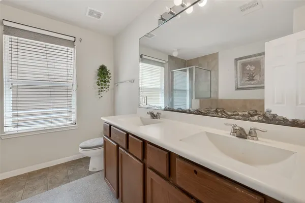 a bathroom with a granite countertop sink a toilet and shower
