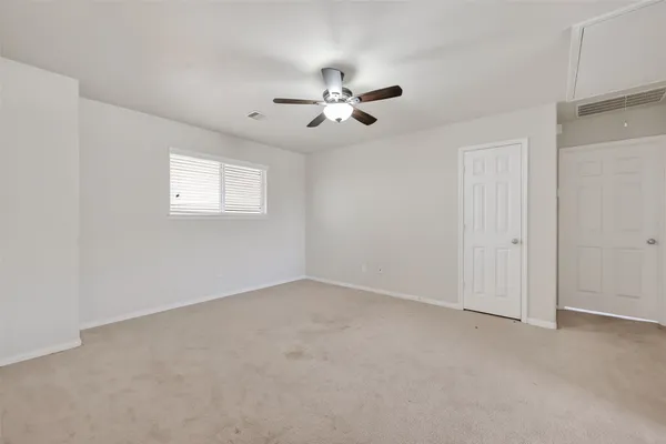an empty room with windows and fan