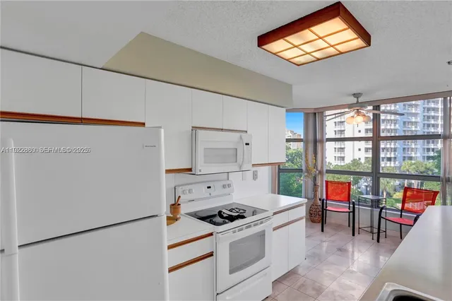 a kitchen with stainless steel appliances granite countertop a stove a refrigerator and a dining table