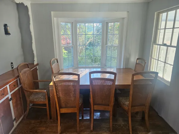 a view of a dining room with furniture large windows and wooden floor
