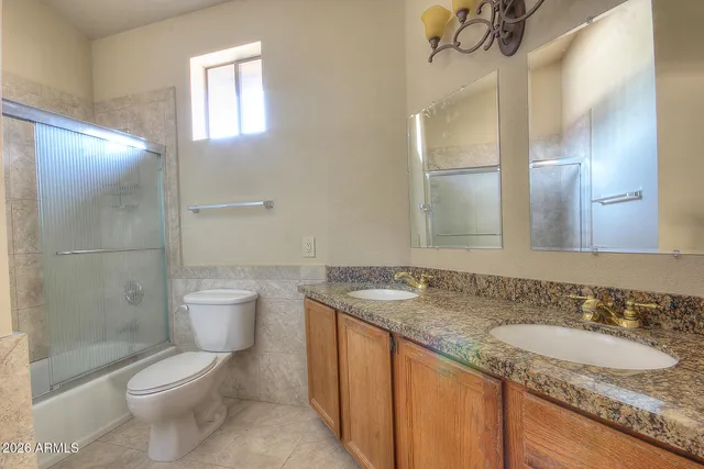 a bathroom with a granite countertop sink a toilet and shower