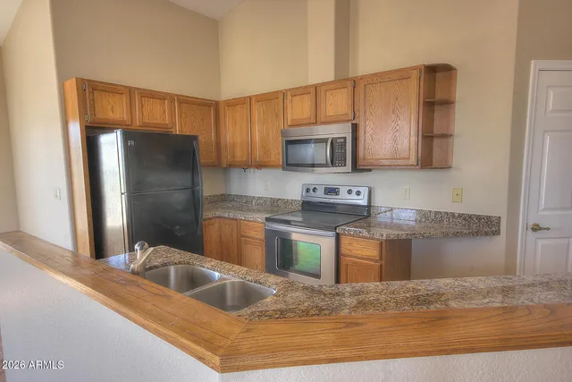 a kitchen with stainless steel appliances granite countertop a sink refrigerator and microwave