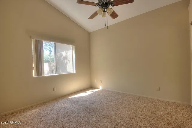 an empty room with a window and a fan