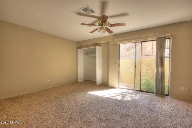 an empty room with a ceiling fan and a window