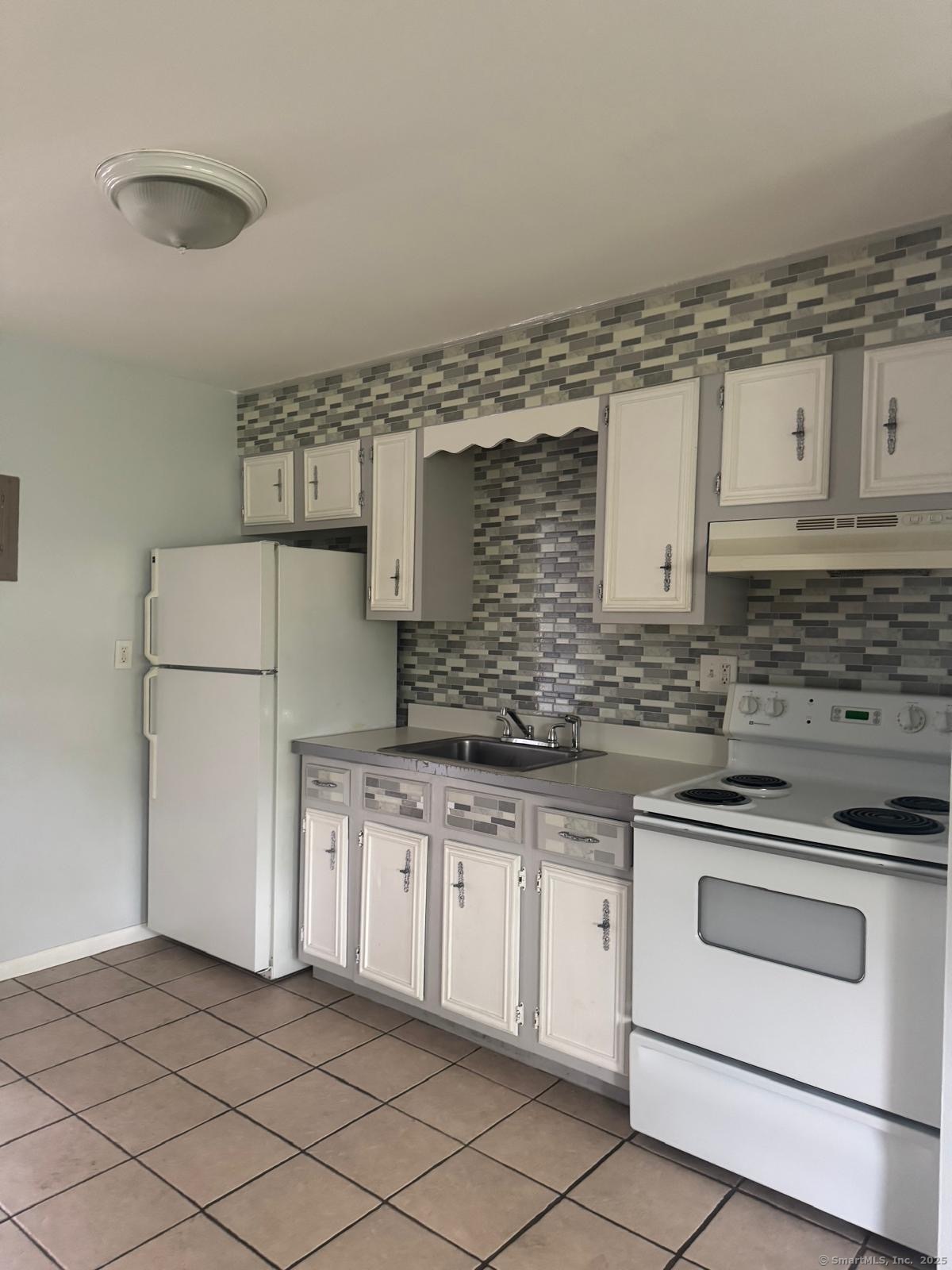 a kitchen with granite countertop white cabinets and white appliances