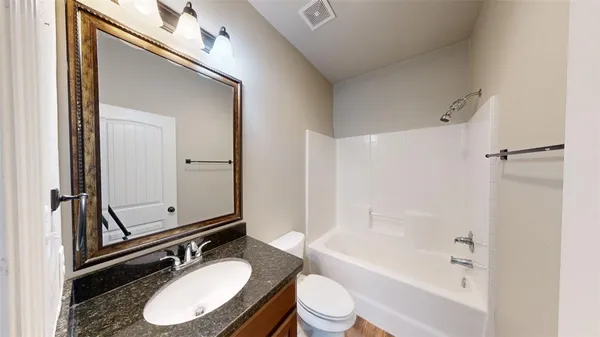a bathroom with a sink a toilet a mirror and shower