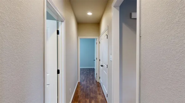 a view of a hallway with wooden floor