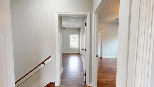 a view of a hallway with wooden floor