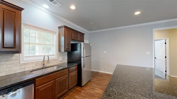 a kitchen with stainless steel appliances granite countertop a sink stove and refrigerator