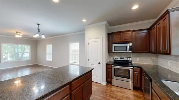 a kitchen with stainless steel appliances granite countertop a stove a sink and a refrigerator
