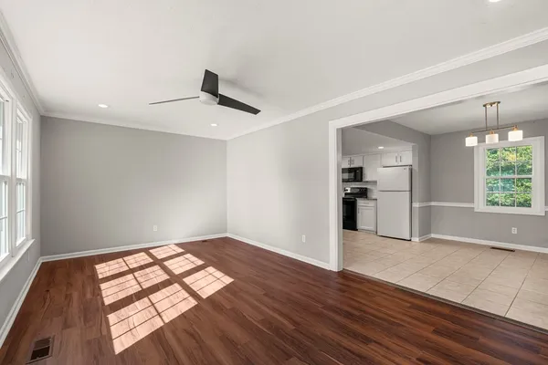 a view of empty room with wooden floor and windows