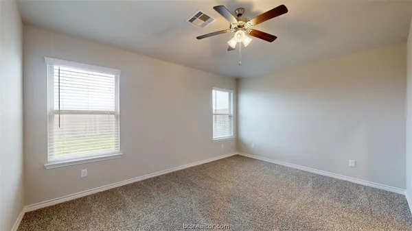 an empty room with a window and a fan