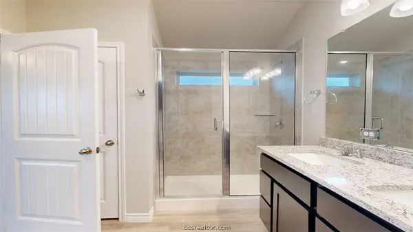 a bathroom with a granite countertop sink mirror and shower