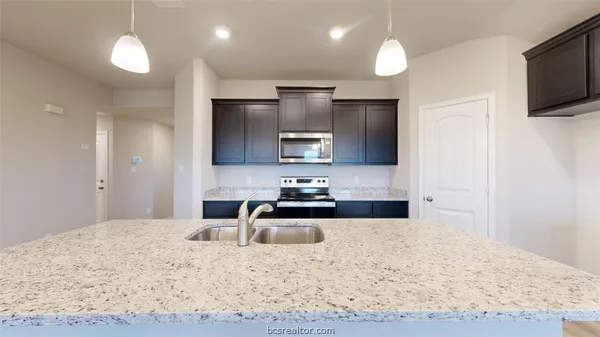 a kitchen with a sink microwave and refrigerator