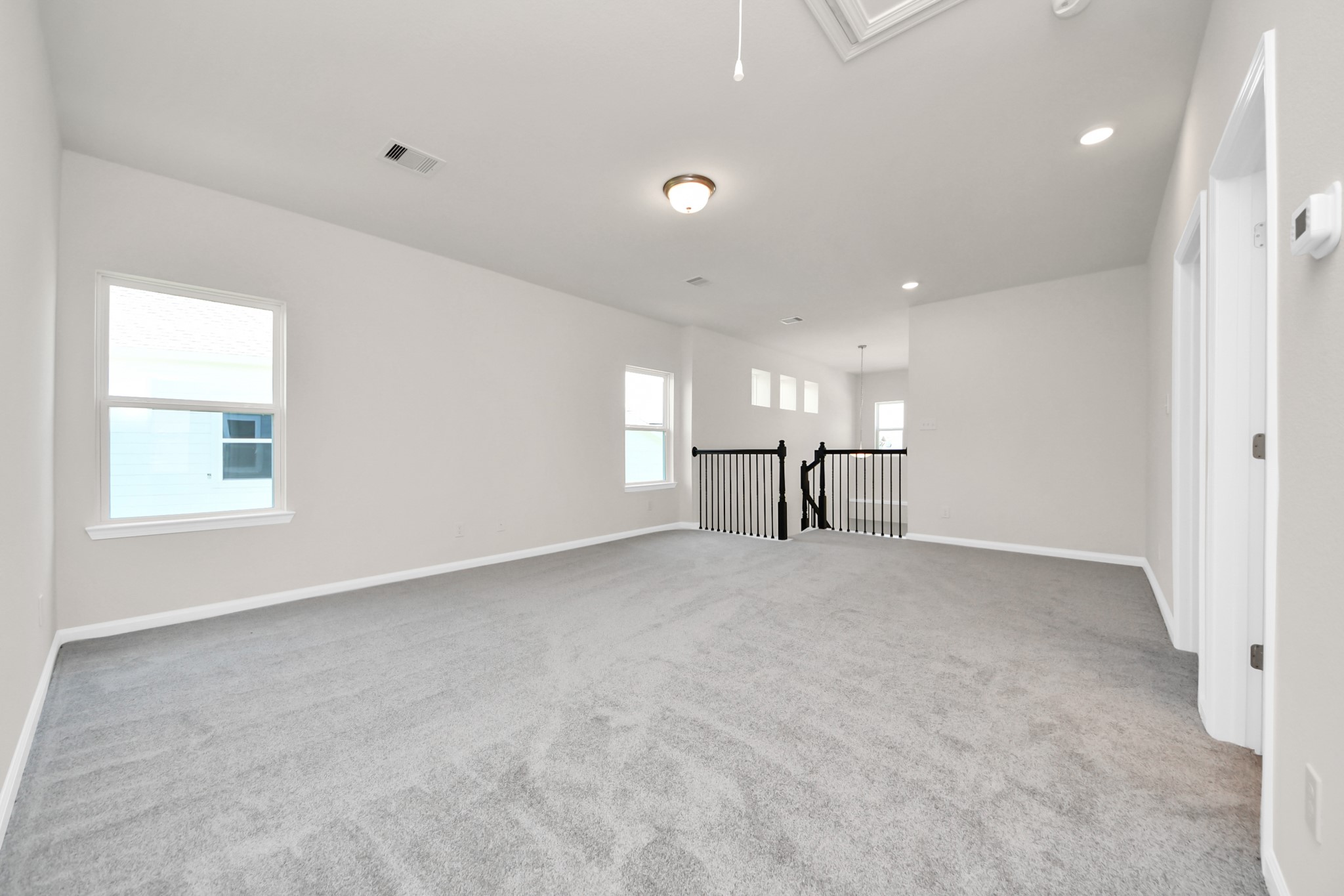 15523 Fathom Line Way Houston, TX 77053 - Photo 11 of 39 This spacious, carpeted room features neutral walls, multiple windows for natural light, and a railing overlooking a stairway. Ideal for a living area, game room or loft space.