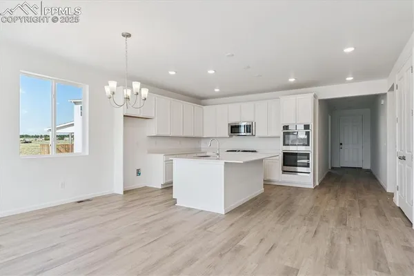 a large kitchen with kitchen island a sink stainless steel appliances and cabinets