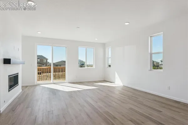 a view of empty room with wooden floor and fireplace