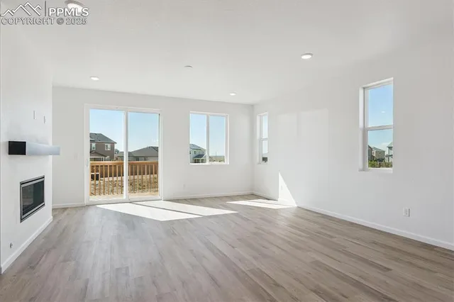 a view of empty room with wooden floor and fireplace