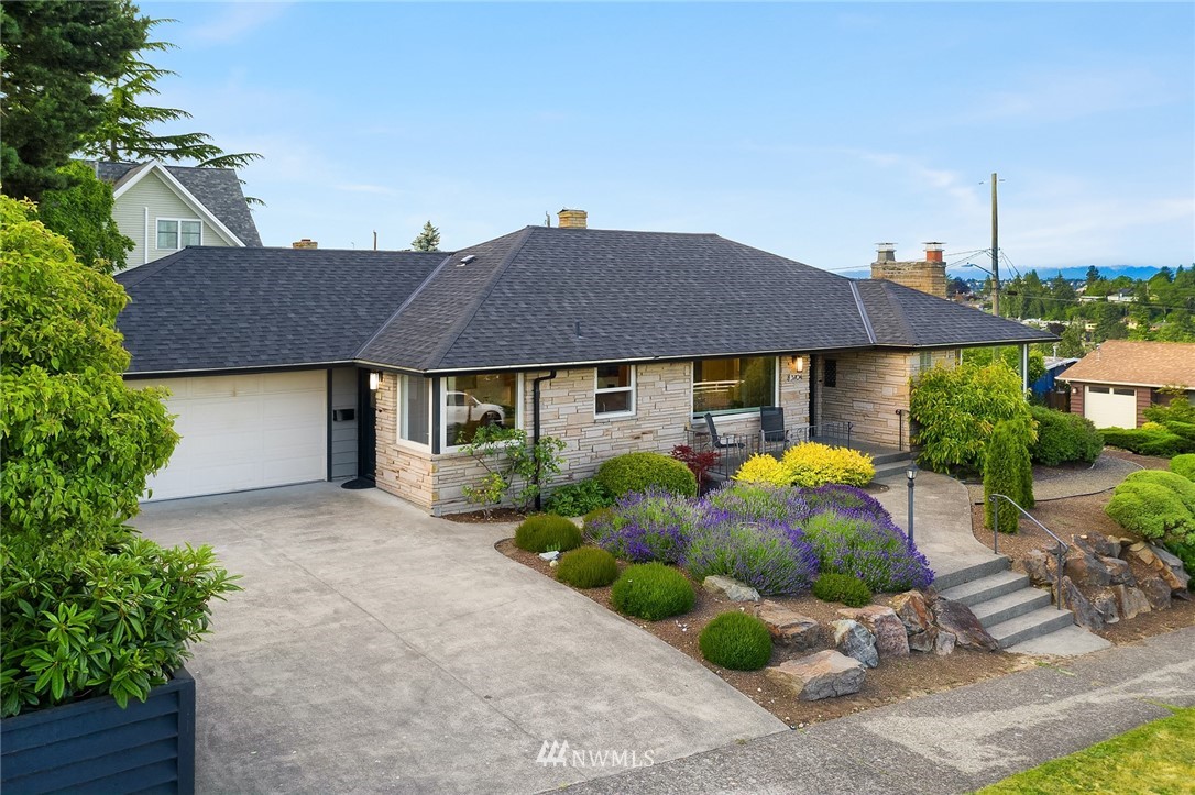 3704 West Dravus Street Seattle, WA 98199 - Photo 34 of 35 a view of house with garden and tall tress