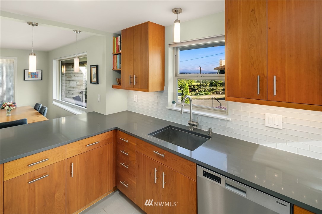 3704 West Dravus Street Seattle, WA 98199 - Photo 9 of 35 a kitchen with granite countertop a sink cabinets and stainless steel appliances