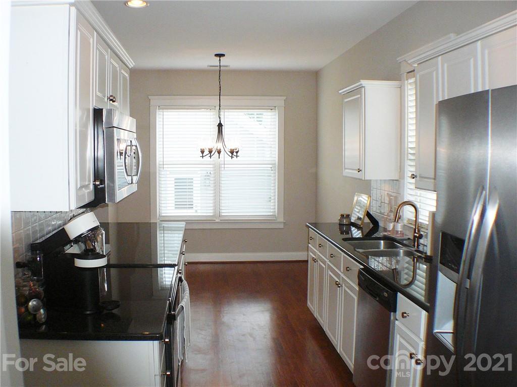 8111 Townley Road Huntersville, NC 28078 - Photo 8 of 27 a kitchen with stainless steel appliances granite countertop a sink stove and refrigerator