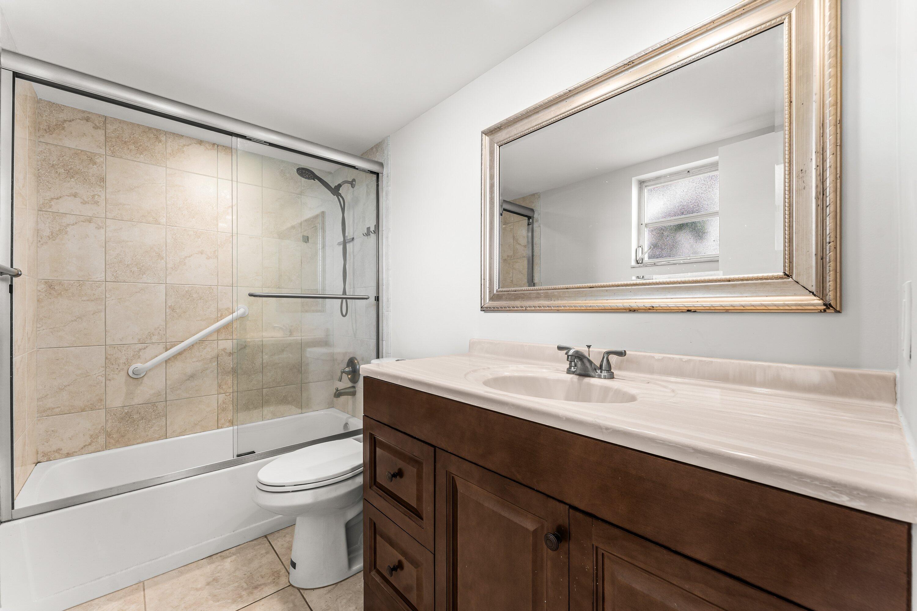 400 Northeast 20th Street, Unit D101 Boca Raton, FL 33431 - Photo 17 of 40 a bathroom with a sink a toilet and shower