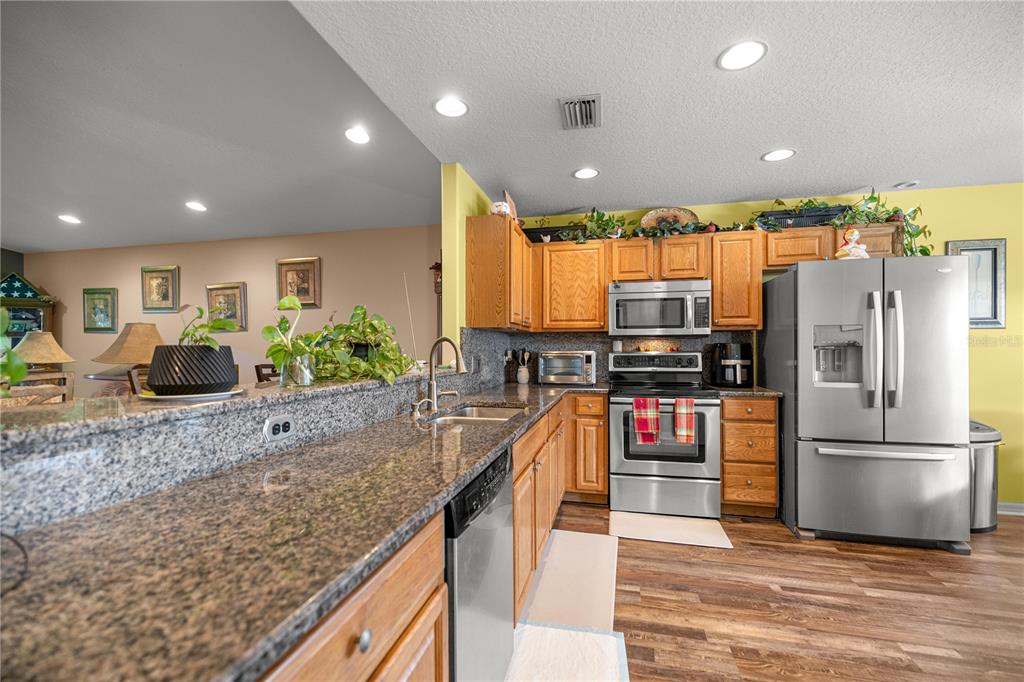 15771 Southwest 13th Circle Ocala, FL 34473 - Photo 6 of 29 a kitchen with stainless steel appliances granite countertop a refrigerator a stove and a sink