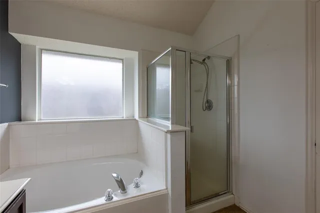 a bathroom with a tub a sink double vanity and a mirror