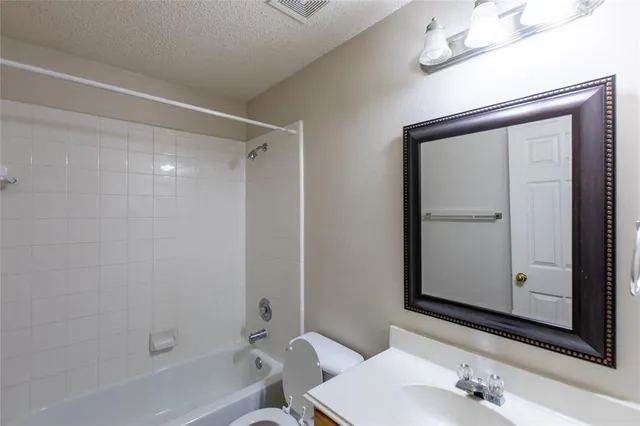 a bathroom with a granite countertop sink mirror and a bathtub