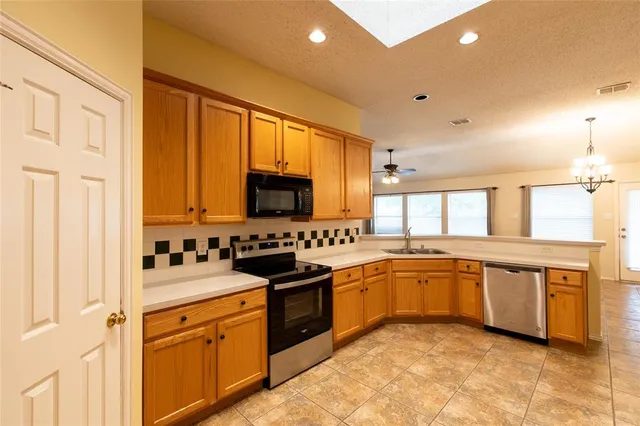 a kitchen with stainless steel appliances granite countertop a stove sink and cabinets