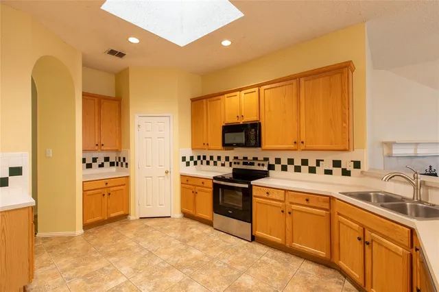 a kitchen with stainless steel appliances granite countertop a stove a sink and a refrigerator