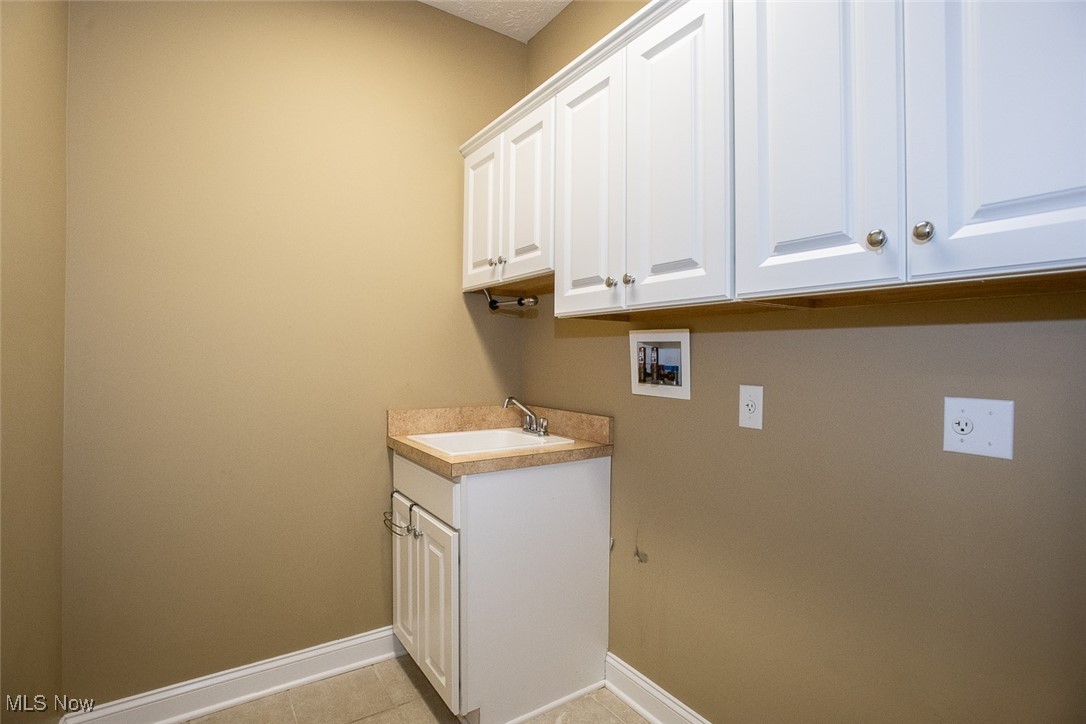 630 Rundle Street Lagrange, OH 44050 - Photo 26 of 49 Laundry area featuring cabinet space, light tile patterned floors, and hookup for a washing machine