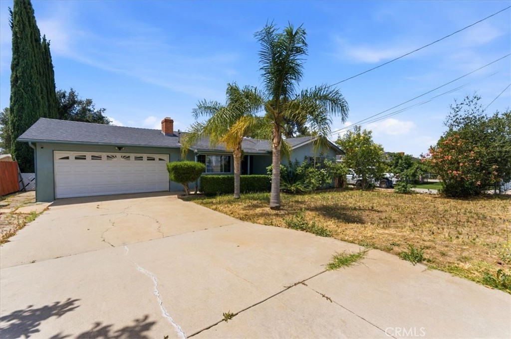 34863 Wildwood Canyon Road Yucaipa, CA 92399 - Photo 2 of 22 a front view of a house with a yard and garage