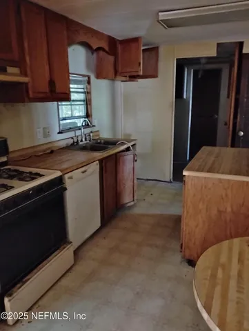 a kitchen with stainless steel appliances granite countertop a sink stove and cabinets