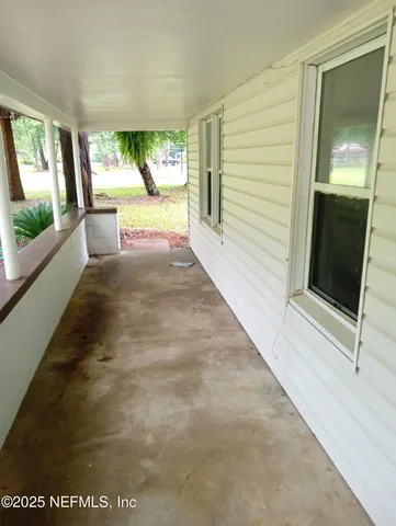 a view of a hallway with wooden floor and windows