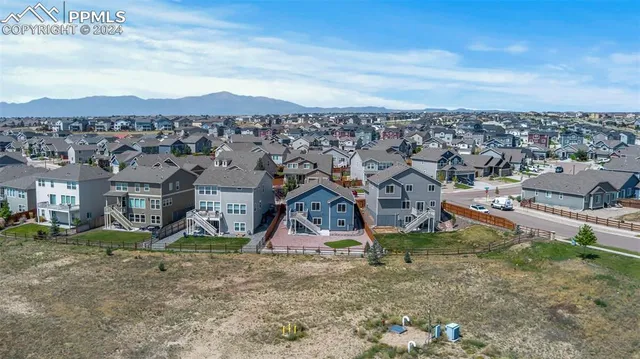 an aerial view of residential houses with outdoor space and street view