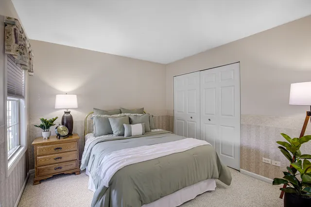 a bedroom with a bed and a potted plant