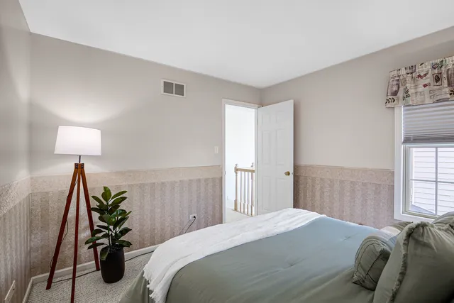 a bedroom with a bed and a lamp