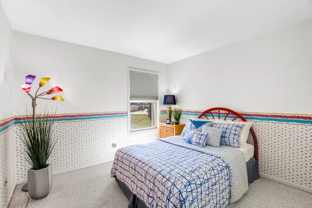 a bedroom with a bed and a potted plant