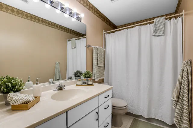 a bathroom with a double vanity sink toilet and a mirror
