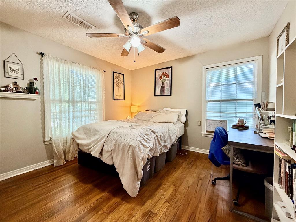 919 Denton Street Denton, TX 76201 - Photo 11 of 19 a bedroom with a bed and a chandelier