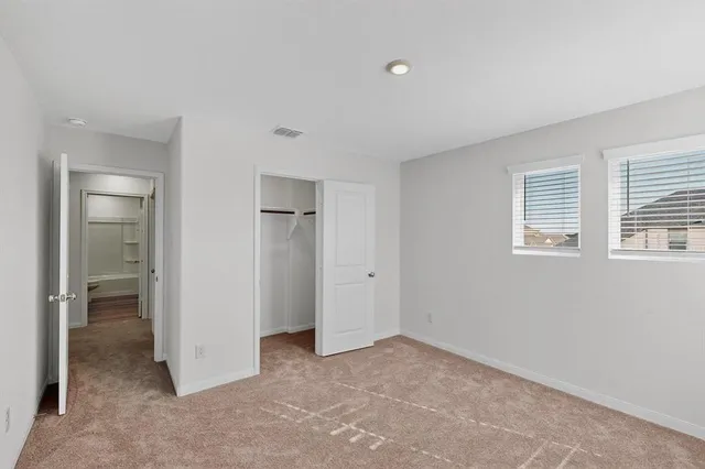 an empty room with windows and closet