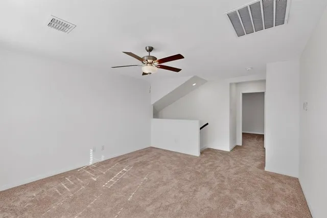 a view of an empty room with closet and a window