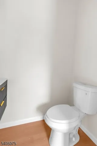 a white toilet sitting next to a white wall