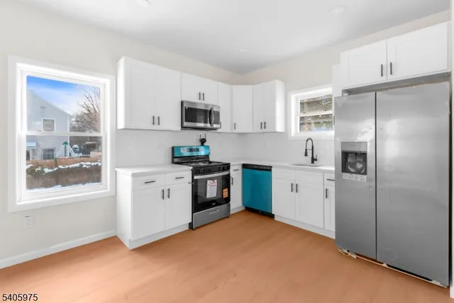 a kitchen with white cabinets and stainless steel appliances