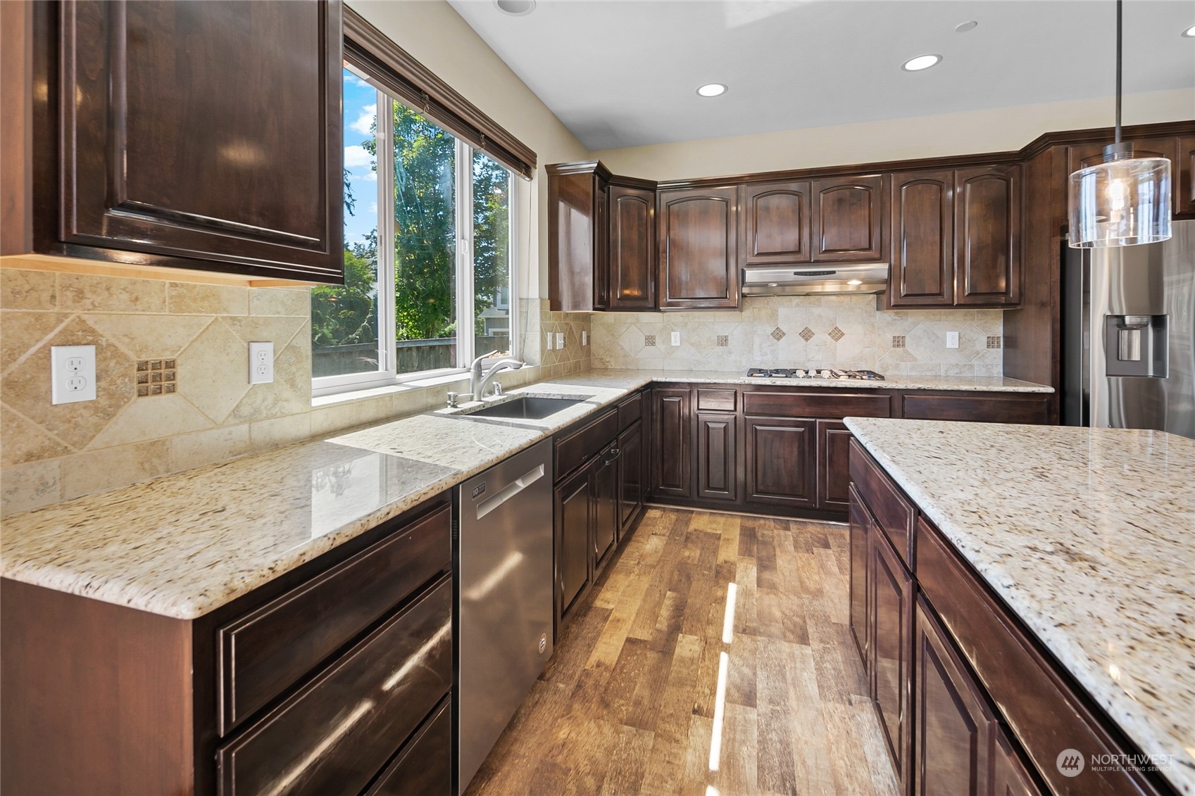 3110 216th Place Southeast Bothell, WA 98021 - Photo 15 of 37 a kitchen with kitchen island granite countertop wooden cabinets a sink and a stove
