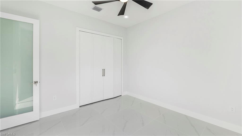 1687 19th Street Southwest Naples, FL 34117 - Photo 13 of 50 an empty room with a ceiling fan and carpet