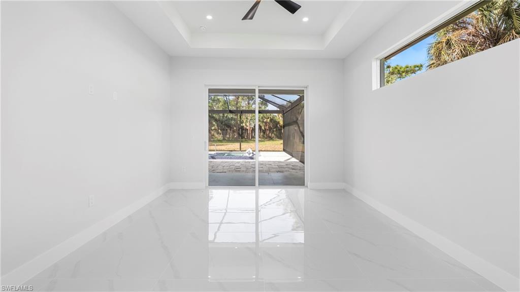 1687 19th Street Southwest Naples, FL 34117 - Photo 20 of 50 Spare room featuring a sunroom, plenty of natural light, marble tiled floors, a ceiling fan, and recessed lighting