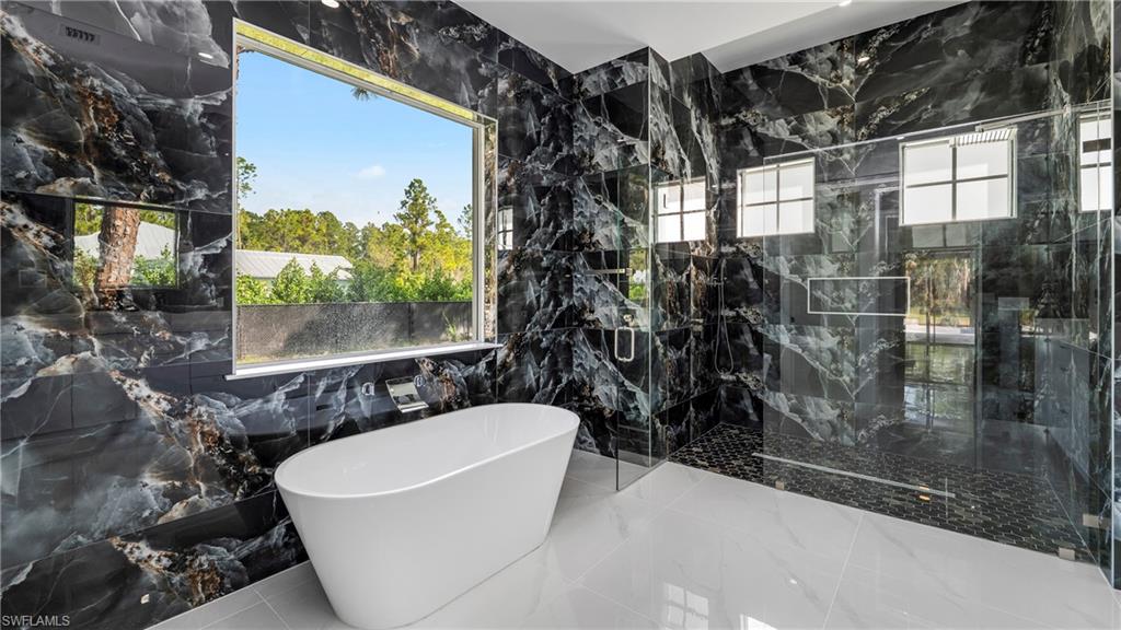 1687 19th Street Southwest Naples, FL 34117 - Photo 23 of 50 Full bathroom with a freestanding tub, a marble finish shower, and tile walls