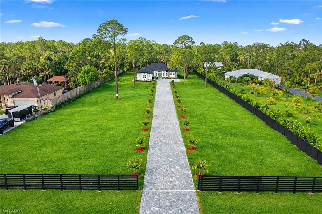 1687 19th Street Southwest Naples, FL 34117 - Photo 3 of 50 Virtually Staged view from above of property with a tree filled landscape and fence